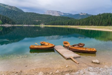 Kuzey Karadağ 'daki Kara Göl veya Crno Jezero manzarası. Avrupa 'nın Zabljak kenti yakınlarındaki Durmitor milli parkında, Kara Göl' deki ahşap rıhtıma yakın turizm tekneleri