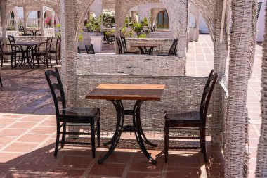 Tahta masa ve sandalyeler Sharm el Sheikh, Mısır 'daki Kızıl Deniz' in yanındaki sahil kafeteryasında.