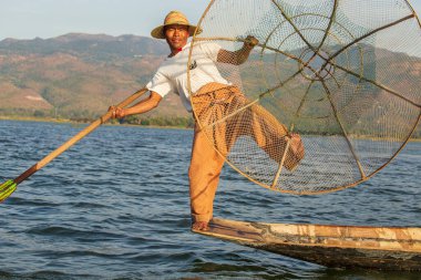 Inle Gölü, Myanmar - 14 Ocak 2016: Bambu teknesinde Burmalı balıkçı el yapımı ağla geleneksel balık yakalıyor. Inle Gölü, Myanmar, Burma