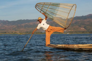 Inle Gölü, Myanmar - 14 Ocak 2016: Bambu teknesinde Burmalı balıkçı el yapımı ağla geleneksel balık yakalıyor. Inle Gölü, Myanmar, Burma