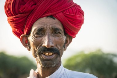 Pushkar, Hindistan - 12 Kasım 2018: Pushkar Camel Mela sırasında çölde Hintli adam Pushkar, Rajasthan, Hindistan yakınlarında. Bu fuar dünyanın en büyük deve ticaret fuarı.