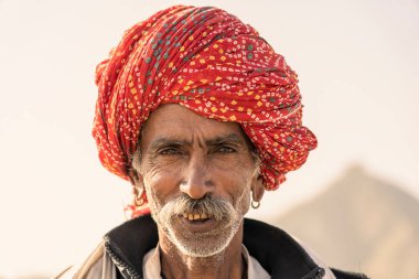 Pushkar, Hindistan - 13 Kasım 2018: Pushkar Camel Mela sırasında çölde Hintli adam Pushkar, Rajasthan, Hindistan yakınlarında. Bu fuar dünyanın en büyük deve ticaret fuarı.