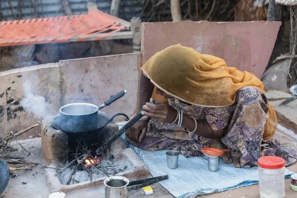 Pushkar, Hindistan - 13 Kasım 2018: Hintli kadın Hindistan 'ın Rajasthan çölünün yakınındaki avluda ailesi için çay yapıyor.