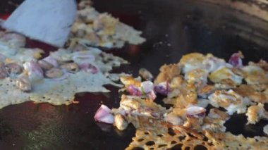 Tayland 'da Koh Phangan Adası' ndaki gece pazarında midyeli omlet pişirmek. Kapat.