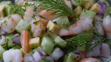 Şef lezzetli karides salatasına zeytinyağı döküyor. Salatalık, peynir ve soğan. Mutfakta. Sağlıklı yemek pişirmek.
