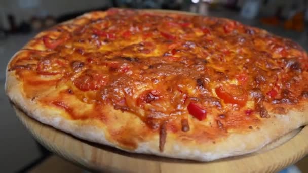 Pizza Mit Käse Tomaten Und Paprika Auf Einem Rotierenden Holztisch — Stockvideo