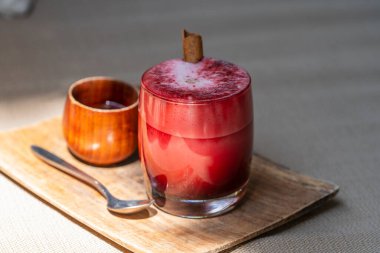 Vanilya ve hindistan cevizi sütüyle harmanlanmış taze pancar kökü vanilyalı latte, tropik kafe, Tayland 'da ahşap masa, yakın çekim. Son moda sağlıklı içecek.