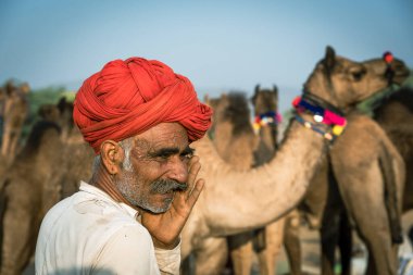 Pushkar, Hindistan - 14 Kasım 2018: Hindistan 'ın kutsal şehri Pushkar, Rajasthan yakınlarındaki Pushkar Camel Mela sırasında çölde yaşayan Hintli adam. Bu fuar dünyanın en büyük deve ticaret fuarı.