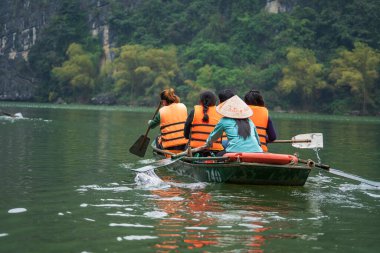 Ninh Binh, Vietnam - Mart 1006, 2020 Trang An Hang Mua, Vietnam 'da Ngo Dong nehrinde insanlarla dolu bir turist botu. Hanoi yakınlarında Kuzey Vietnam 'ın güzel doğası