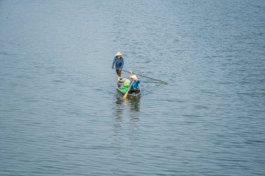 Hue, Vietnam - 12 Mart 2020: Hue şehrinde, Vietnam 'da iki Vietnamlı kadın kürek çekiyor.