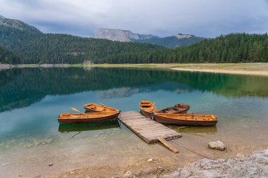 Kuzey Karadağ 'daki Kara Göl veya Crno Jezero manzarası. Avrupa 'nın Zabljak kenti yakınlarındaki Durmitor milli parkında, Kara Göl' deki ahşap rıhtıma yakın turizm tekneleri