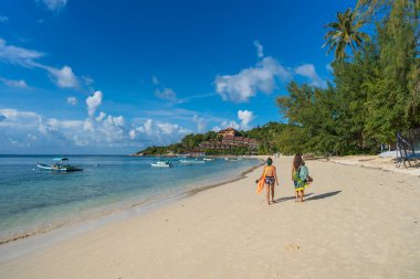 Koh Phangan, Tayland - 13 Şubat 2022: Genç iki kız Tayland 'ın Koh Phangan adasında deniz kenarında yürüyor