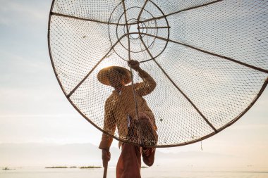 Inle Gölü, Myanmar - 14 Ocak 2016: Bambu teknesinde Burmalı balıkçı el yapımı ağla geleneksel balık yakalıyor. Inle Gölü, Myanmar, Burma