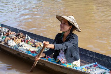 Inle Gölü, Myanmar - 14 Ocak 2016: Birmanyalı kadın küçük tahta bir teknede hediyelik eşya, incik boncuk ve bijouterieat the floater market, Inle Lake, Myanmar
