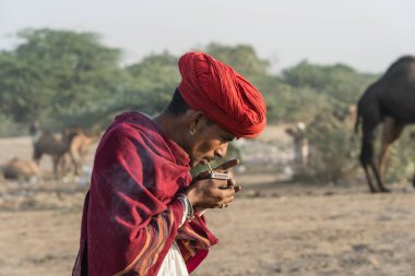 Pushkar, Hindistan - 14 Kasım 2018: Hindistan 'ın kutsal şehri Pushkar, Rajasthan yakınlarındaki Pushkar Camel Mela sırasında çölde yaşayan Hintli adam. Bu fuar dünyanın en büyük deve ticaret fuarı.