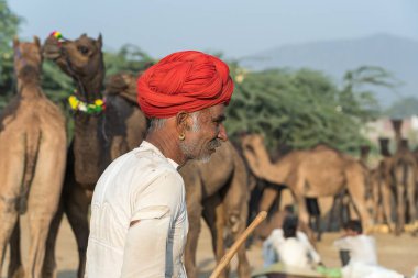 Pushkar, Hindistan - 14 Kasım 2018: Hindistan 'ın kutsal şehri Pushkar, Rajasthan yakınlarındaki Pushkar Camel Mela sırasında çölde yaşayan Hintli adam. Bu fuar dünyanın en büyük deve ticaret fuarı.