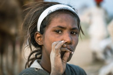 Pushkar, Hindistan - 14 Kasım 2018: Çölde sigara içen Hintli genç kız Thar zamanında Pushkar Camel Mela kutsal şehir Pushkar, Rajasthan, Hindistan, yakın portre