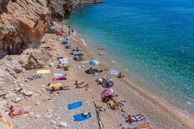 Pasjaca plajı, Hırvatistan - Sep 01, 2021: Avrupalı turistler Hırvatistan 'ın Dubrovnik kenti yakınlarındaki Adriyatik Denizi üzerindeki Avrupa' nın en iyi plajında dinleniyorlar