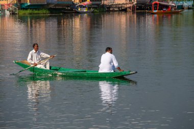 Srinagar, Hindistan - Temmuz 02, 2015: Dal Gölü 'nde yaşam tarzı, Hindistan' ın Srinagar, Jammu ve Kashmir eyaletlerinde küçük bir taşımacılık teknesi olan Shikara 'yı kullanıyor. Teknedeki Hintli adamlar