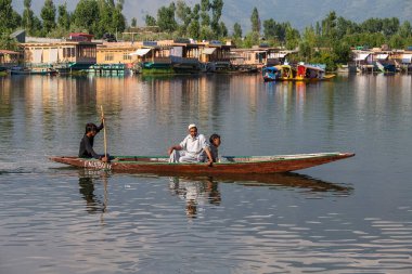 Srinagar, Hindistan - Temmuz 02, 2015: Dal Gölü 'nde yaşam tarzı, Hindistan' ın Srinagar, Jammu ve Kashmir eyaletlerinde küçük bir taşımacılık teknesi olan Shikara 'yı kullanıyor. Teknedeki Hintli adamlar