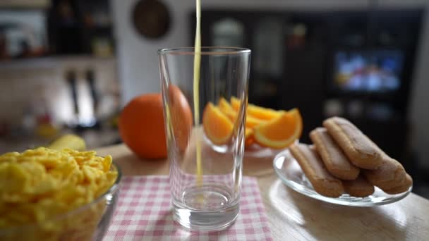 キッチンの回転テーブルの透明なガラスに新鮮なオレンジジュースを入れ ゆっくりとした動きを閉じます 天然の有機ビタミンドリンクで健康的な朝食を調理します — ストック動画