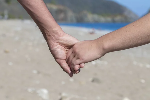 Några Händer Höll Ihop Nära Blått Havsvatten Stranden Bakgrund Närbild — Stockfoto