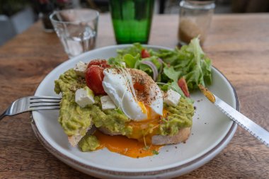 Ekşi ekmek, haşlanmış yumurta, avokado hamuru ve kafede taze sebzeler, kapanış, kahvaltı zamanı.