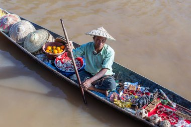 Inle Gölü, Myanmar, Burma - 14 Ocak 2016: Küçük, uzun tahta bir teknede hediyelik eşya, incik boncuk ve bijouterieat satan Burmalı adam