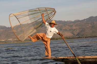 Inle Gölü, Myanmar - 14 Ocak 2016: Bambu teknesinde Burmalı balıkçı el yapımı ağla geleneksel balık yakalıyor. Inle Gölü, Myanmar, Burma