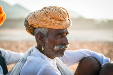 Pushkar, Hindistan - 12 Kasım 2018: Pushkar Camel Mela sırasında çölde Hintli adam Pushkar, Rajasthan, Hindistan yakınlarında. Bu fuar dünyanın en büyük deve ticaret fuarı.