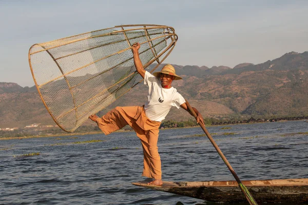 Inle Gölü, Myanmar - 14 Ocak 2016: Bambu teknesinde Burmalı balıkçı el yapımı ağla geleneksel balık yakalıyor. Inle Gölü, Myanmar, Burma