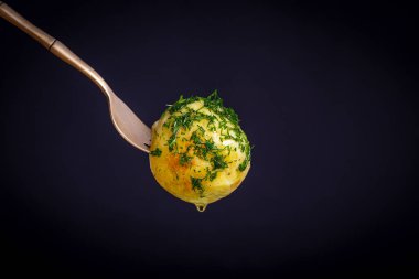 Siyah arka planda haşlanmış taze patatesli çatal. Kapat.