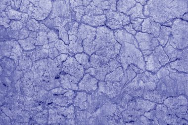 Arka plan olarak bej çimento yüzeyi ile kaplı çatlamış eski bir duvar. Çatlak desenli eski bir duvar. 2022 yılının moda rengi. Filmin Ultra Violet yaratıcı ve karamsar rengi
