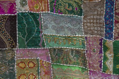 Hindistan 'ın arka planındaki renkli halının detaylarını anlat. Kapat.