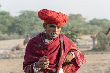 Pushkar, Hindistan - 14 Kasım 2018: Hindistan 'ın kutsal şehri Pushkar, Rajasthan yakınlarındaki Pushkar Camel Mela sırasında çölde yaşayan Hintli adam. Bu fuar dünyanın en büyük deve ticaret fuarı.