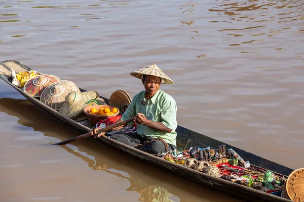 Inle Gölü, Myanmar, Burma - 14 Ocak 2016: Küçük, uzun tahta bir teknede hediyelik eşya, incik boncuk ve bijouterieat satan Burmalı adam