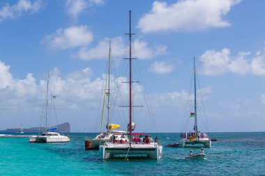 Mauritius Adası - 18 Mart 2017: Mauritius Adası, güneşli bir yaz gününde Hint Okyanusu kıyısında yüzen bir turist katamaranı görüntüsü