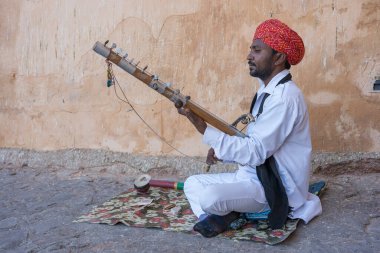 Jaipur, Hindistan - 26 Kasım 2018: Hindistan 'ın eski kenti Jaipur, Rajasthan' daki Amber Kalesi 'nde turistler için Kamaycha adı verilen geleneksel müzik enstrümanında Hint folk müzisyeni