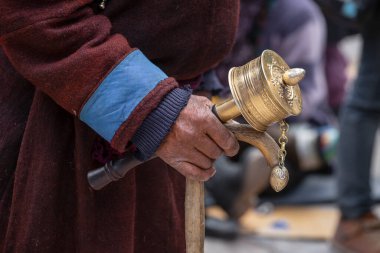Lamayuru Gompa, Ladakh, Hindistan 'da sopa ve dua çarklı yaşlı Tibetli adam. Kapat.