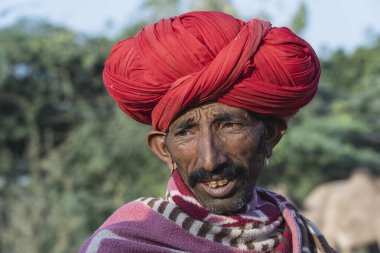Pushkar, Hindistan - 14 Kasım 2018: Hindistan 'ın kutsal şehri Pushkar, Rajasthan yakınlarındaki Pushkar Camel Mela sırasında çölde yaşayan Hintli adam. Bu fuar dünyanın en büyük deve ticaret fuarı.