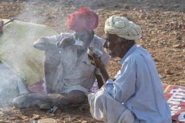 Pushkar, Hindistan - 14 Kasım 2018: Hindistan 'ın kutsal şehri Pushkar, Rajasthan yakınlarındaki Pushkar Camel Mela sırasında çölde yaşayan Hintli erkekler. Bu fuar dünyanın en büyük deve ticaret fuarı.
