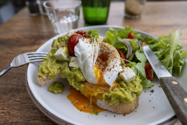 Ekşi ekmek, haşlanmış yumurta, avokado hamuru ve kafede taze sebzeler, kapanış, kahvaltı zamanı.