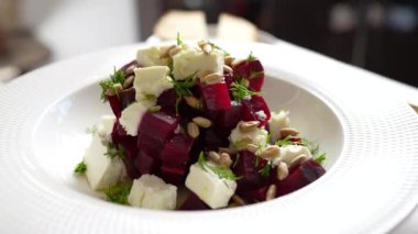 Pancar köklü sağlıklı salata, beyaz tabakta beyaz peynir ve ayçiçeği tohumları, kapatın, döndürür