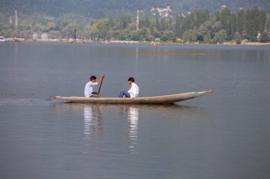 Srinagar, Hindistan - Temmuz 02, 2015: Dal Gölü 'nde yaşam tarzı, Hindistan' ın Srinagar, Jammu ve Kashmir eyaletlerinde küçük bir taşımacılık teknesi olan Shikara 'yı kullanıyor. Teknedeki Hintli adamlar