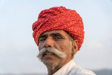 Pushkar, Hindistan - 14 Kasım 2018: Hindistan 'ın kutsal şehri Pushkar, Rajasthan yakınlarındaki Pushkar Camel Mela sırasında çölde yaşayan Hintli adam. Bu fuar dünyanın en büyük deve ticaret fuarı.