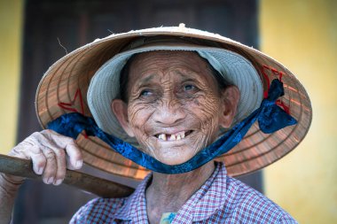 Hoi An, Vietnam - 01 Temmuz 2020: Hoi An, Vietnam 'da bir sokak pazarında saman şapkalı yaşlı kadın
