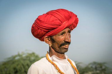 Pushkar, Hindistan - 14 Kasım 2018: Hindistan 'ın kutsal şehri Pushkar, Rajasthan yakınlarındaki Pushkar Camel Mela sırasında çölde yaşayan Hintli adam. Bu fuar dünyanın en büyük deve ticaret fuarı.