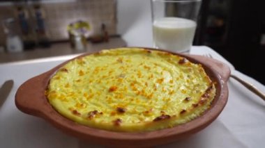 Kuru üzümlü ve irmikli süzme peynir güveci. Fırında pişmiş peynirli güveç ile seramik kase, yakın çekim. Kahvaltı için sağlıklı süt ürünleri.