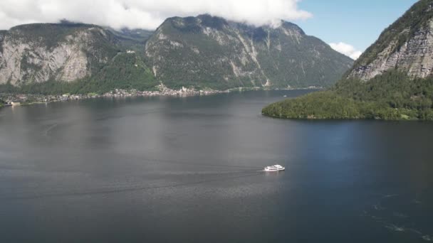 奥地利哈尔斯塔特村旁边的哈尔斯塔特湖 旅游船和高山阿尔卑斯山的空中景观 旅游与自然概念 — 图库视频影像