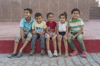 Sharm El Sheikh, Mısır - 17 Mayıs 2021: Mısırlı çocuklar Sharm El Sheikh, Mısır, Afrika 'daki tatil köyünün merkezindeki kaldırımda dinleniyorlar.